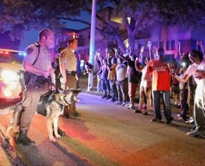 This August, mostly white cops sick themselves and a snarling dog on black protesters in Ferguson, Missouri. They were protesting over a black man shot in the streets.