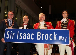 Niagara Region Chair Alan Caslin, Brock University President Jack Lightstone, Maj.-Gen. Sir Isaac Brock (played by actor Guy Bannerman) and aide de camp John Glegg (played by Brock student Mike Fusilo) introduce the street sign that people will be seeing on the new Sir Isaac Brock Way.