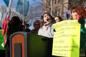 Ontario Health Coalition's executive director Natalie Mehra at podium outside Queen's Park following submission to provincial legislative committee on hospital funding.
