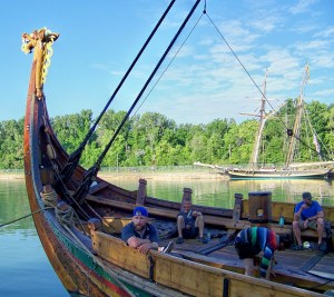 Crew member Thomas Olsen (left) on board the Viking ship Draken Harald Harfagre in Niagara community of Port Weller at head of Welland Canada. A reproduction of the War of 1812 ship Pride of Baltimore is docked in the background. Photo by Doug Draper